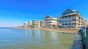 Un hôtel situé au bord de l’eau, doté de nombreux balcons, offrant une vue dégagée sur l’eau et présentant un toit plat.