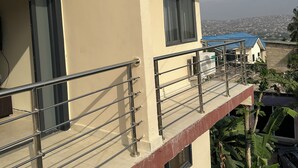 Ein mehrstöckiges Gebäude mit Balkonen, einer Überwachungskamera und Blick auf die Stadt.