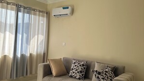 Ein Wohnzimmer mit einer Couch, einem Couchtisch und einer Klimaanlage.