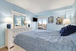 A bedroom with a bed, dresser, and artwork on the walls. - Oceanfront Condo w/ Gorgeous View, 2 Balconies, Central Air & Shared Pool (Ocean City)