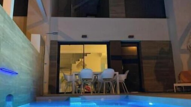 A modern building with a swimming pool, outdoor seating, and a staircase. - Flamenco House (Rojales)