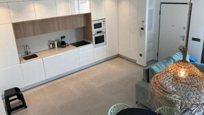 A modern kitchen with white cabinets, a built-in oven, and a sink. - Flamenco House (Rojales)