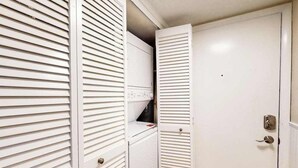 Une pièce blanche avec une porte fermée, un mur blanc et un plafond blanc.