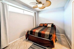 A bedroom with a bed, a ceiling fan, and a carpeted floor. - Wight Bay North 442 (Ocean City)