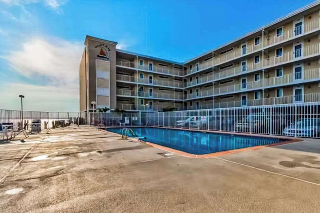 Un hôtel à plusieurs étages doté d’une piscine et d’un parking clos.