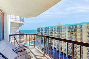 Un balcon avec vue sur l’océan et un espace piscine.