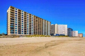 A multi-story hotel with a uniform facade, located near a beach. - Beachfront/ocean-view condo with private balconies (Ocean City)