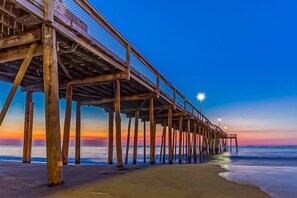 A wooden pier extending into the water with a clear sky above. - White Marlin 303B (Ocean City)