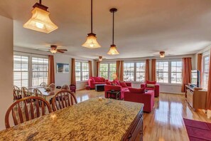 A spacious living area with a dining table, red sofas, and large windows. - Spacious home w/ community pools, tennis, & docks - ADA compliant (Ocean City)