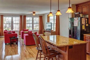 A modern kitchen with a central island, wooden cabinets, and pendant lighting. - Spacious home w/ community pools, tennis, & docks - ADA compliant (Ocean City)