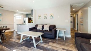 Una sala moderna con un sofá, una mesa de centro y un comedor con sillas.