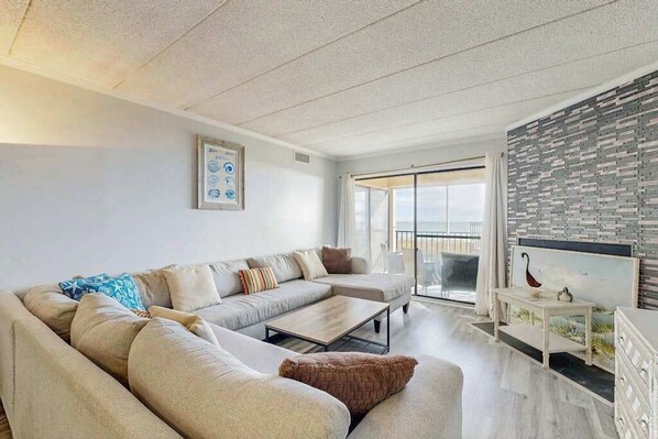 Una sala de estar moderna con un sofá, una mesa de centro y un televisor sobre un mueble.