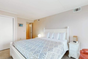 A bedroom with a bed, bedside table, and a nightstand. - Sixth-floor oceanfront condo w/central AC, washer/dryer, furnished balcony (Ocean City)