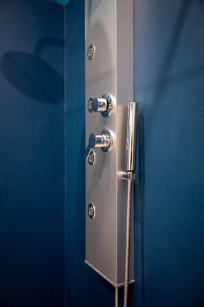 A modern shower with a chrome finish, a control panel, and a flexible hose. - Hotiday Relais di Gusto (La Spezia)