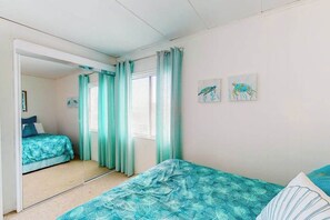 A bedroom with a bed, a mirror, and two wall-mounted pictures. - 124 East 304 (Ocean City)