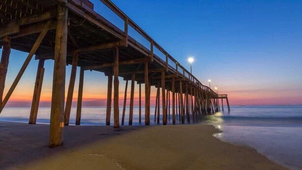 A pier extending into calm waters at dusk with a clear sky. - Jocelyn Manor Unit 85 (Ocean City)