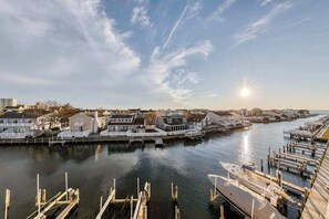 A marina with docked boats, a clear sky, and buildings along the water. - Harbour Club A9 (Ocean City)