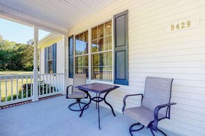 A covered porch with a table and two chairs, a white house exterior, and a mailbox with the number 9429. - Family-Friendly Home Close to OC w/Furnished Porch, Central A/C, & Free WiFi (Berlin)