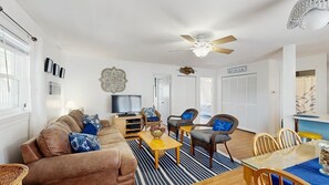 A living room with a sofa, chairs, a TV, and a dining table. - Alexandra 103 (Ocean City)