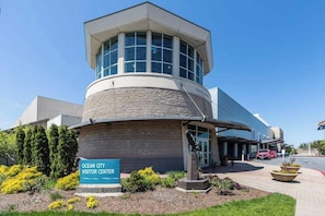 Ein Gebäude mit einer geschwungenen Fassade, einem markanten Turm mit großen Fenstern und einem Schild mit der Aufschrift 'Ocean City Visitor Center'.