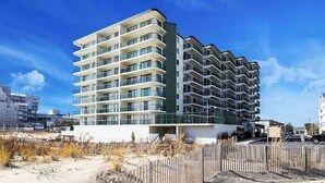 A multi-story hotel with balconies, located near a beach. - Beachy Getaway Steps From Water w/Shared Pool, WiFi, AC, & Private Washer/Dryer (Ocean City)