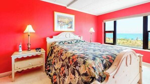 A bedroom with a bed, two bedside tables, a window with a view, and a framed picture on the wall. - Oceanfront Mooring Condo w/ Ocean View, WiFi, W/D, AC - Relax and Unwind (Ocean City)