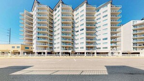 A multi-story hotel with a parking lot in front.