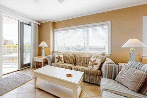 A living room with a sofa, a coffee table, and two lamps. - Meridian Condo w/ Ocean View, WiFi, AC, W/D, Shared Pool/Gym - Steps to Beach (Ocean City)