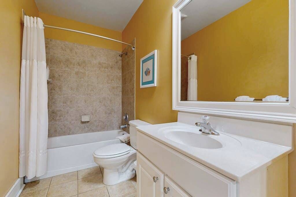 A bathroom with a bathtub, toilet, and sink.