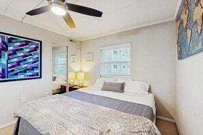A bedroom with a bed, a ceiling fan, a world map artwork, and a window with blinds. - Bright Beach Home Near the Boardwalk W/ Beach Access, Free WiFi & Balcony (Ocean City)