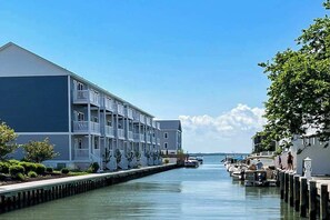 Ein Hotel am Wasser mit mehreren Balkonen, einer Anlegestelle und Booten.