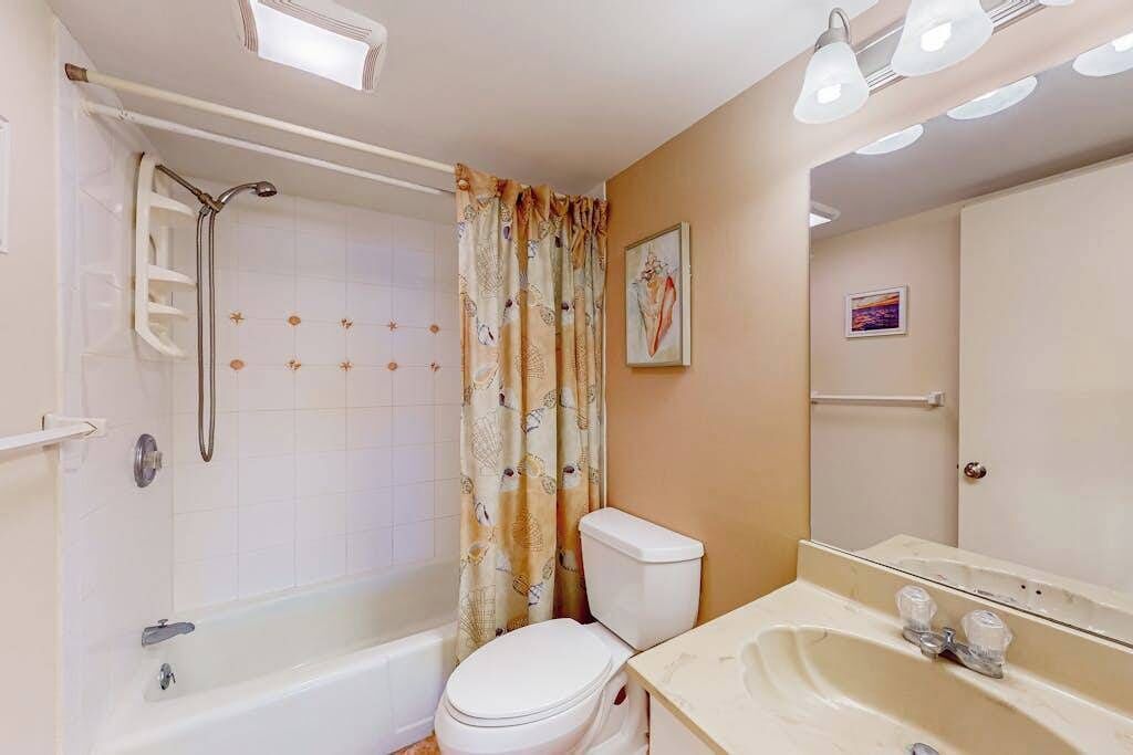 A bathroom with a bathtub, toilet, and sink.