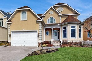 A two-story house with a garage, a front porch, and a small entryway. - Heron Harbour Retreat 302 Gull Ct (Ocean City)