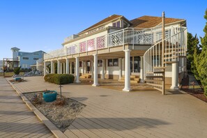 A waterfront hotel with a covered outdoor area, columns, and a spiral staircase. - Waterfront Secured Compound in West Ocean City: Your Dream Escape (Ocean City)