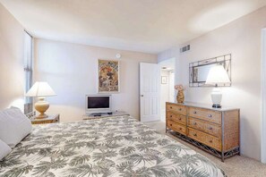 A bedroom with a bed, a dresser, a television, and a poster on the wall. - Fountainhead Towers  1607 (Ocean City)