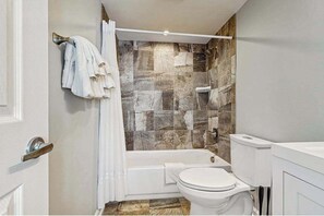 Ein Badezimmer mit Dusche, Toilette und Badewanne.