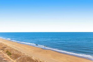 Ein Strand mit blauem Himmel und ruhigem Meer.