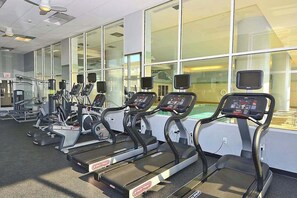 Ein Fitnessstudio mit Laufbändern, Crosstrainern und Gewichtsmaschinen.