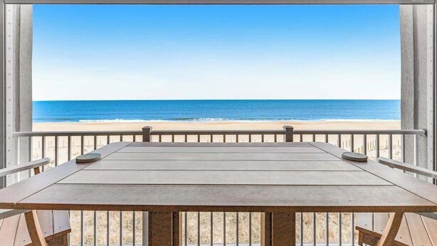 Een houten tafel met uitzicht op het strand en de oceaan.