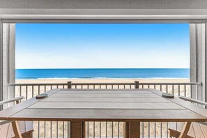 Ein Holztisch mit Blick auf Strand und Meer.