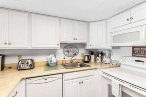 Fridge, microwave, oven, stovetop - Oceanfront Pelican Beach condo with sunrise ocean views, AC, laundry & WiFi (Ocean City)