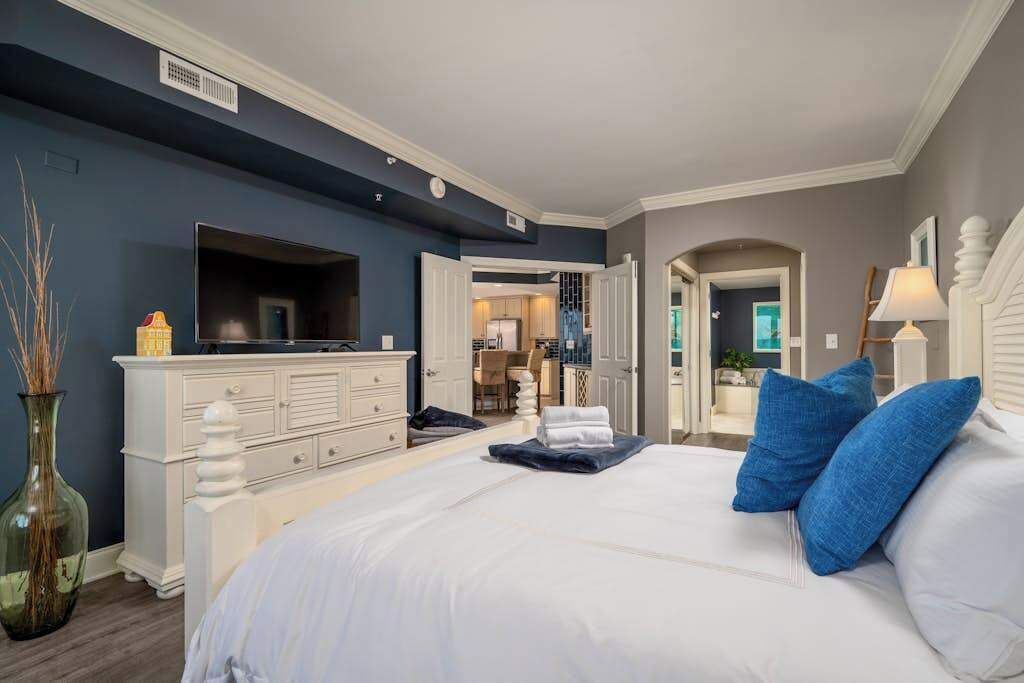 Une chambre à coucher avec un lit, une commode et une vue sur la salle de bain.