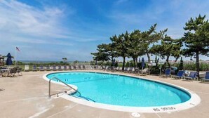 A swimming pool with lounge chairs and a flag. - Beach Club 127 A (Ocean City)