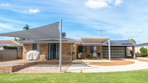 A residential property with a covered patio, a garage, and a brick exterior. - Welcoming 3-Bed House with Large Backyard (Mandurah)
