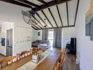 A spacious living area with a dining table, sofa, and a unique ceiling light fixture. - Welcoming 3-Bed House with Large Backyard (Mandurah)