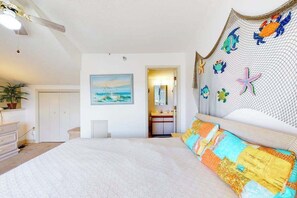 A bedroom with a bed, a painting, a bathroom door, and a ceiling fan. - Two-Level Condo with Balcony, Central AC, Washer/Dryer & WiFi - Near the Beach (Ocean City)