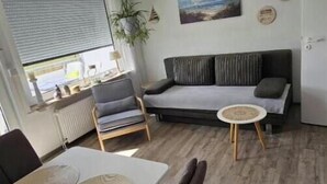 Un salon moderne avec un canapé, une table à manger et des chaises.