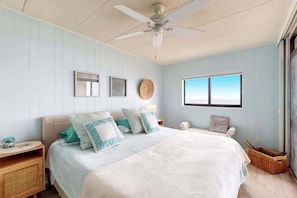 A bedroom with a bed, a nightstand, a lamp, a ceiling fan, a window, and a wall-mounted picture. - Boca Grande 504 (Ocean City)