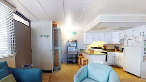 A compact living space with a kitchenette, a sofa, and a dining area. - First-Floor, Ocean Block Condo with Patio, AC, WiFi & Laundry - Steps to Beach (Ocean City)