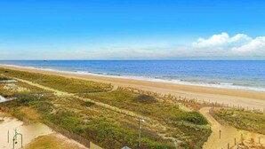 A beach view with a fence, a path, and a clear sky. - Astounding beach condo with balcony, pools, gym, game room & tennis (Ocean City)